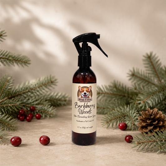Bottle of 'Barkberry Woods' spray with a label featuring a dog's face, surrounded by pine branches and berries on a neutral background.