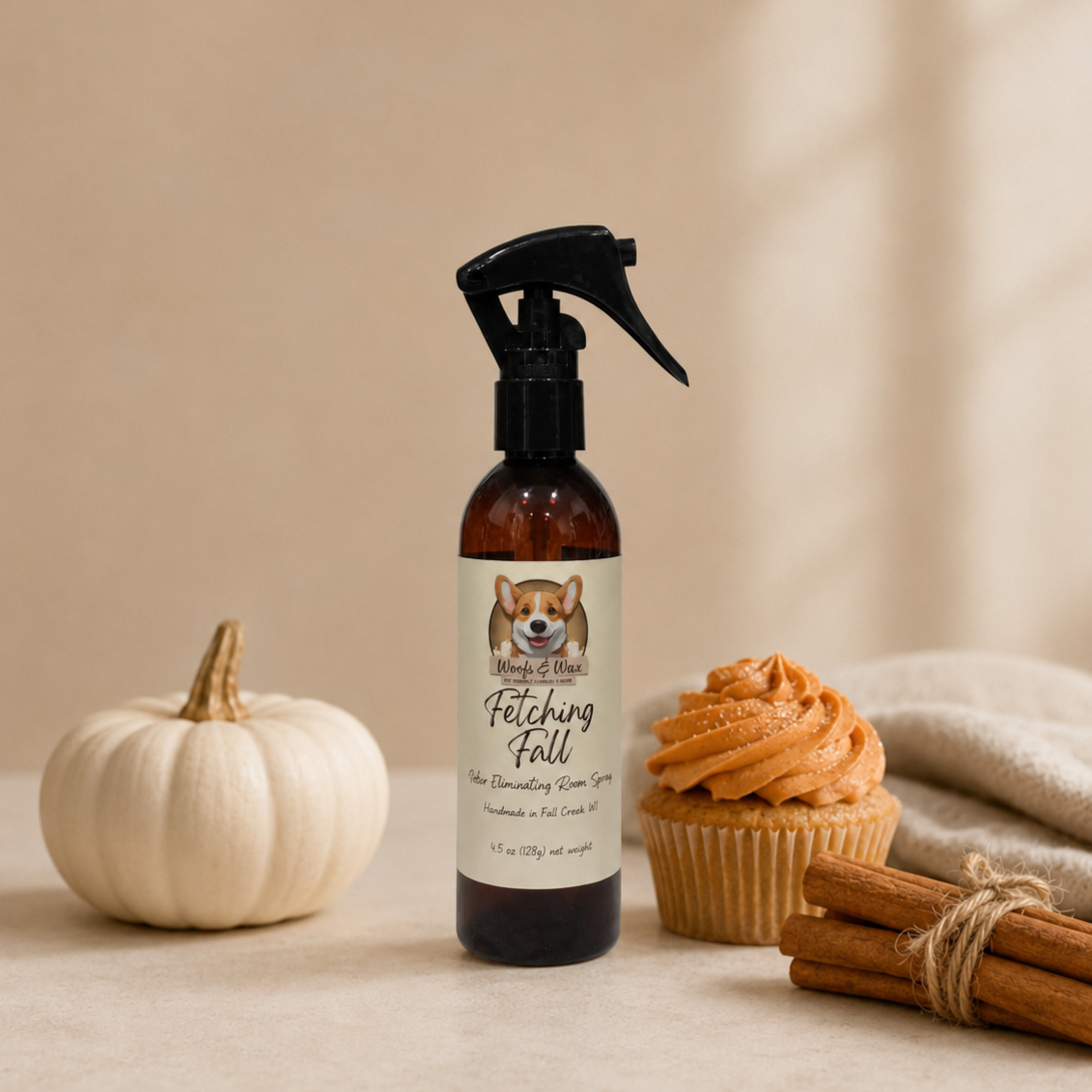 Bottle of 'Fetching Fall' room spray with a pumpkin, cupcake, and cinnamon sticks on a beige background