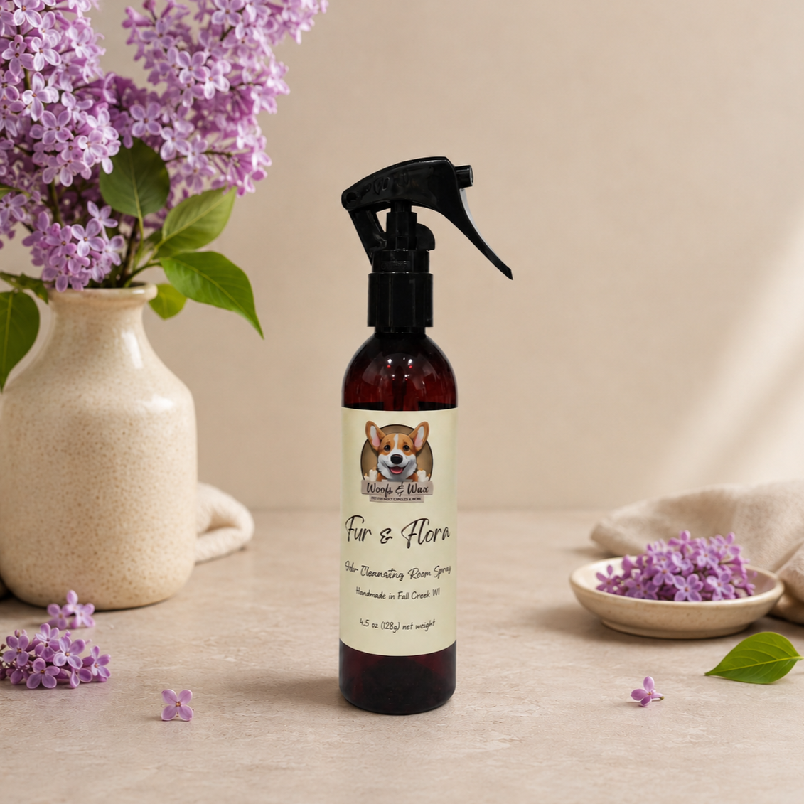 Spray bottle labeled 'Fur & Flora' with a vase of purple flowers on a wooden surface.
