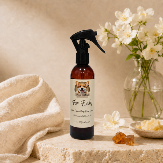 Bottle of 'Fur Baby' spray on a table with flowers and towel in the background