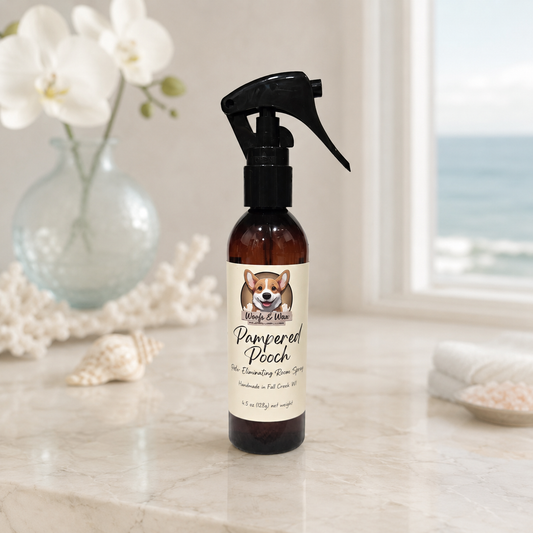 Bottle of 'Pampered Pooch' room spray product on a marble surface with decorative elements.
