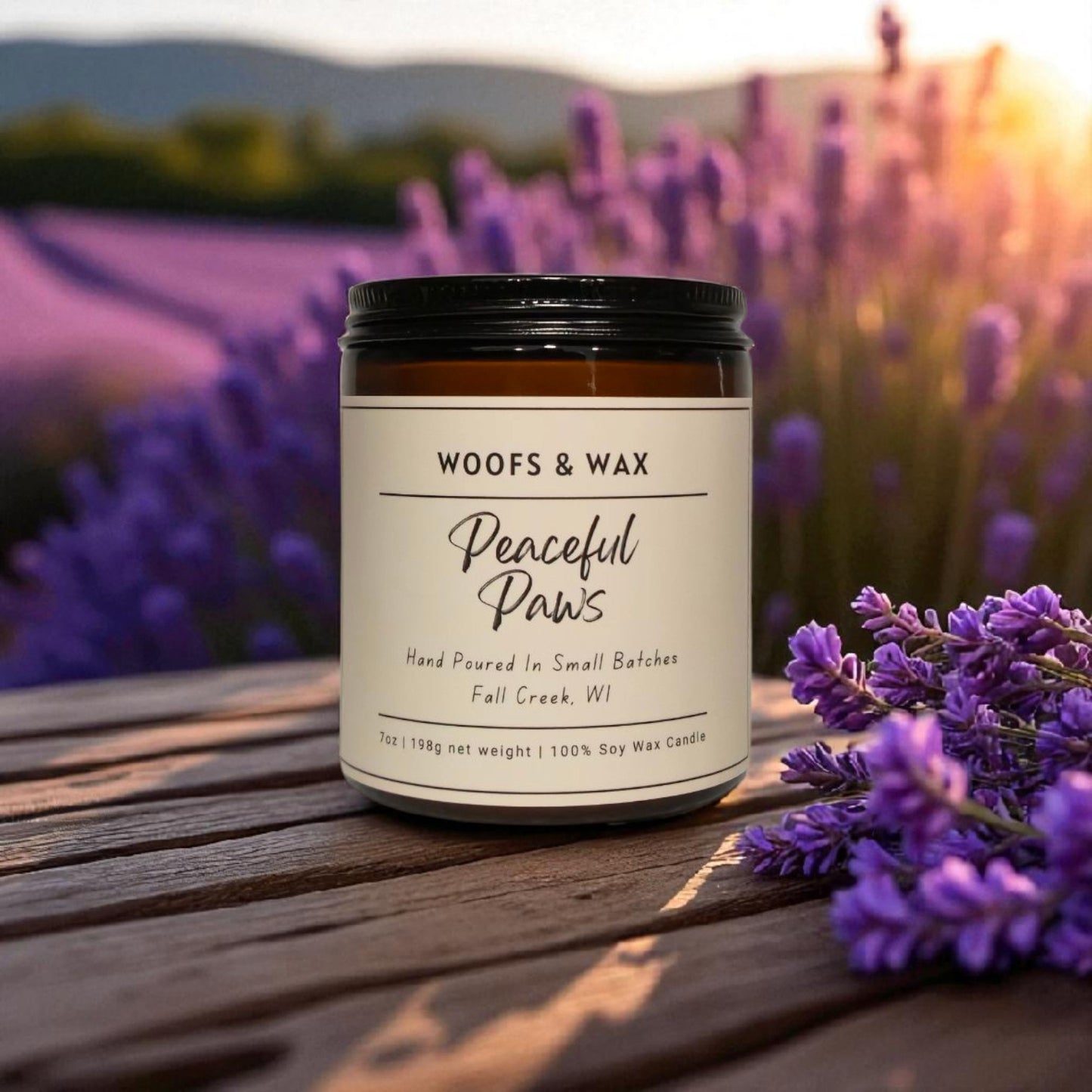 Candle jar labeled 'Woofs & Wax Peaceful Paws' on a wooden surface with lavender flowers in the background.