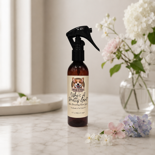 Spray bottle labeled 'Who's A Pretty Girl' on a marble surface with flowers in the background