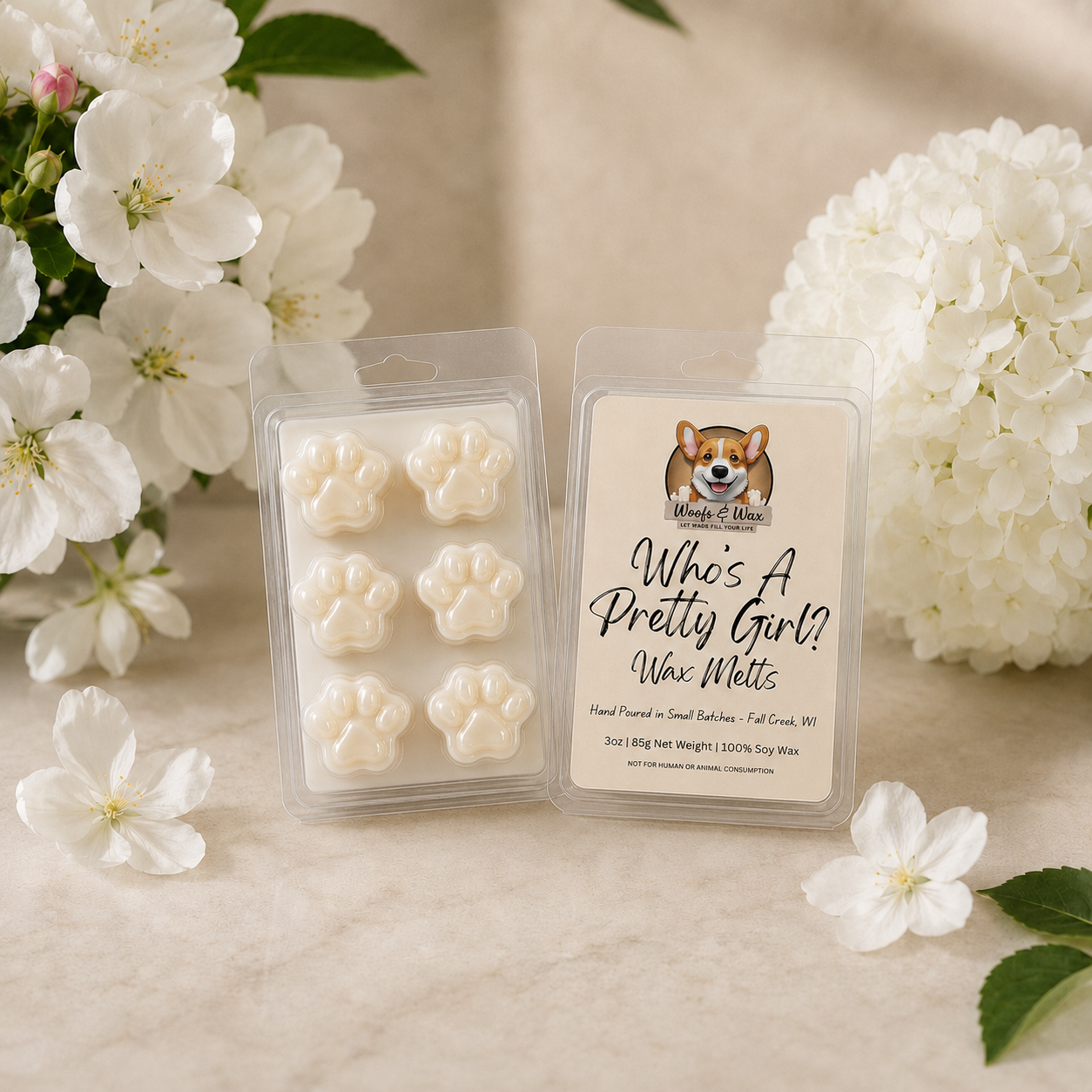 Packaged wax melts with a dog illustration and text, surrounded by white flowers on a light background