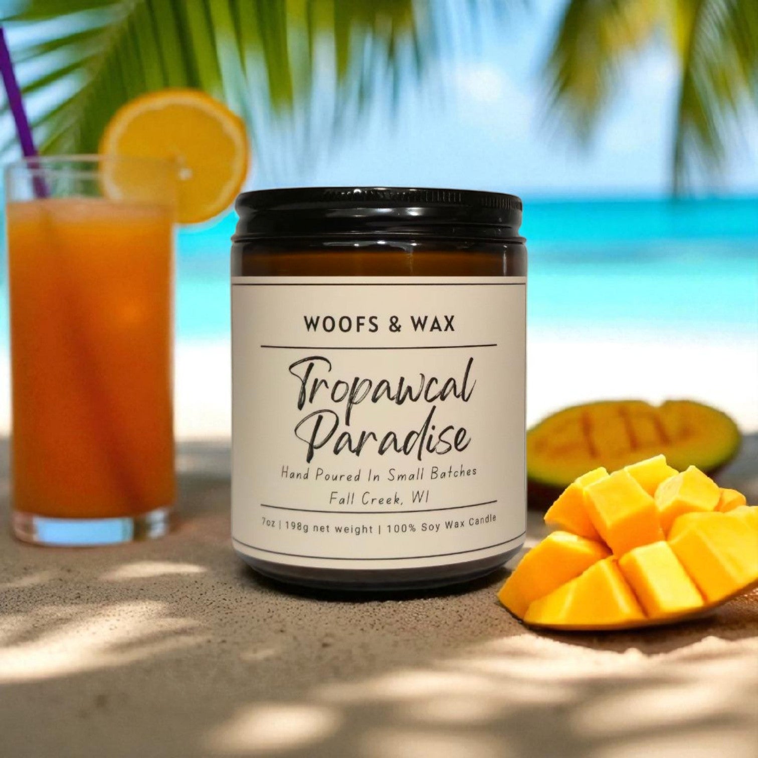 Candle labeled 'Woofs & Wax Tropawcal Paradise' with a tropical setting featuring a drink and fruit.